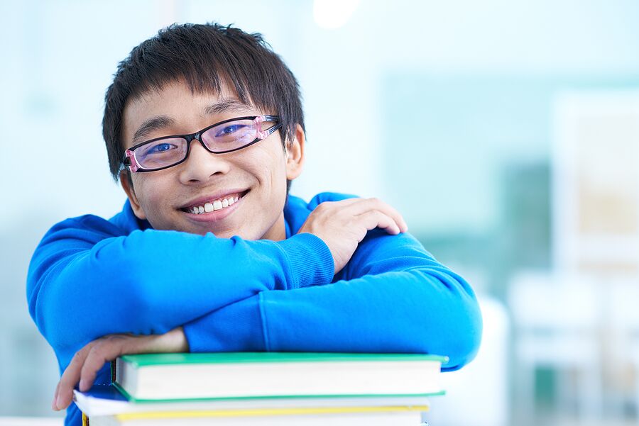 Portrait of successful Asian student in eyeglasses looking at camera